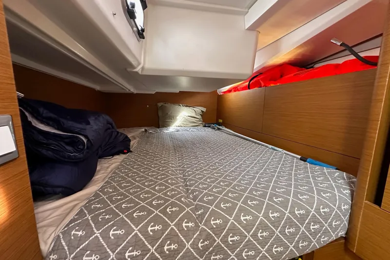  Yacht Photos Pics Cozy cabin interior of 2019 Jeanneau Sun Odyssey 440 sailboat with anchor-patterned bedding.