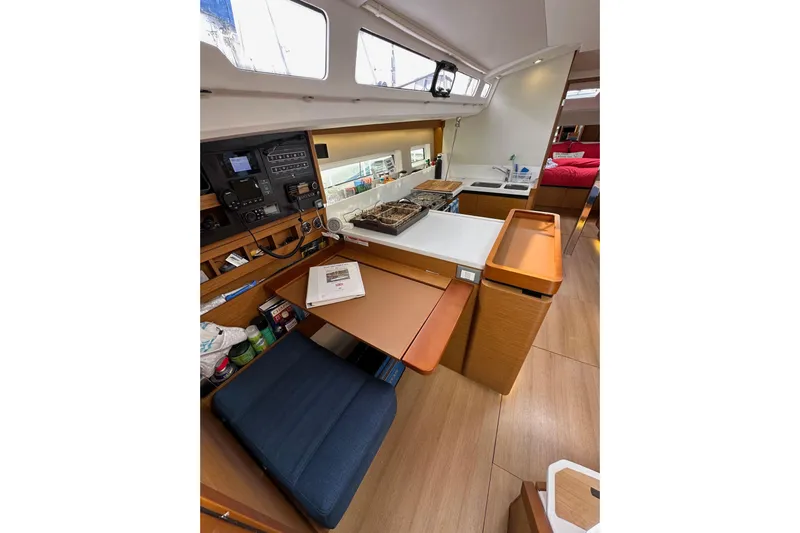  Yacht Photos Pics Interior of 2019 Jeanneau Sun Odyssey 440 sailboat, featuring a compact kitchen and navigation area.