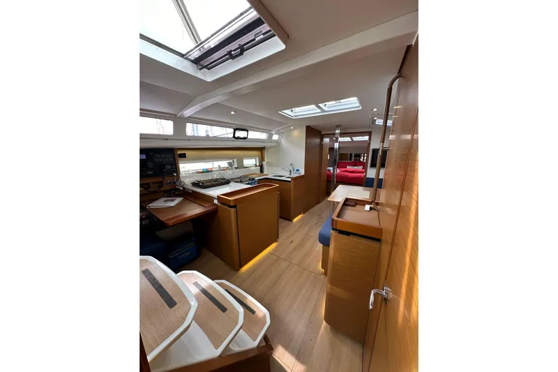  Yacht Photos Pics Interior of 2019 Jeanneau Sun Odyssey 440 yacht, featuring modern wood finishes and skylights.