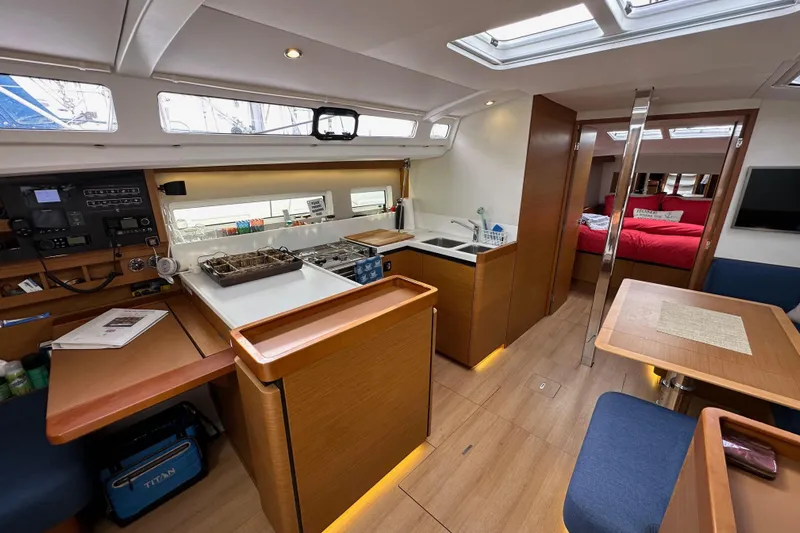  Yacht Photos Pics Interior of 2019 Jeanneau Sun Odyssey 440 yacht, featuring modern kitchen and cozy seating area.