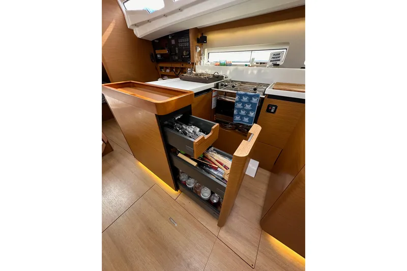  Yacht Photos Pics Interior of 2019 Jeanneau Sun Odyssey 440 yacht kitchen with modern cabinetry and pull-out storage.