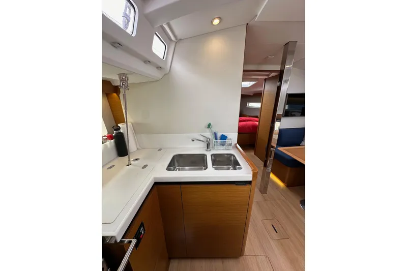  Yacht Photos Pics Interior of 2019 Jeanneau Sun Odyssey 440 yacht, featuring modern kitchen and cozy seating area.
