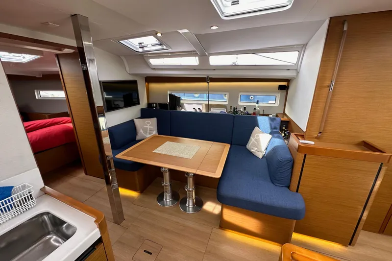  Yacht Photos Pics Interior of 2019 Jeanneau Sun Odyssey 440 yacht with cozy seating and dining area.