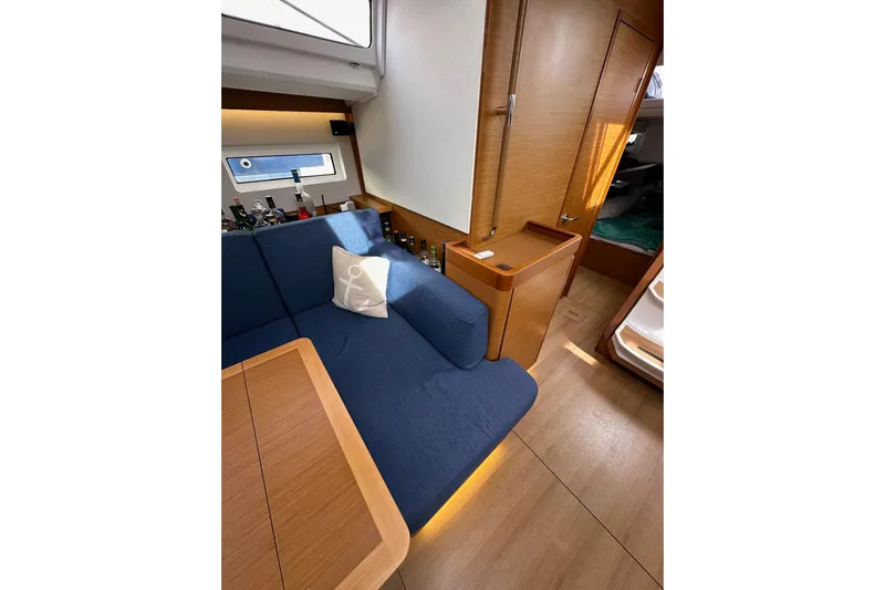 Yacht Photos Pics Interior of 2019 Jeanneau Sun Odyssey 440 yacht with blue seating and wooden finishes.