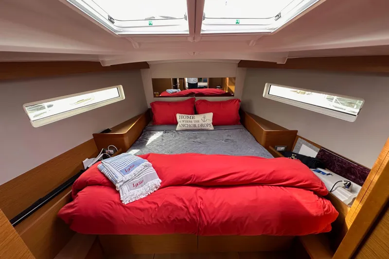  Yacht Photos Pics Luxurious cabin interior of 2019 Jeanneau Sun Odyssey 440 with red bedding and skylights.