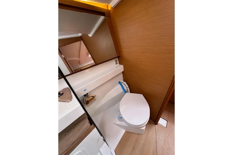  Yacht Photos Pics Bathroom interior of 2019 Jeanneau Sun Odyssey 440 yacht, featuring modern design and wooden accents.