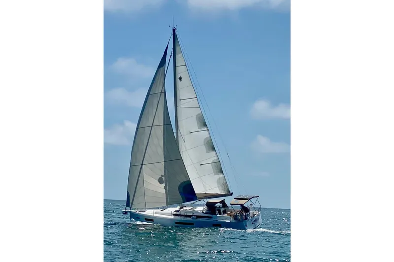  Yacht Photos Pics 2019 Jeanneau Sun Odyssey 440 sailing on open water under clear blue skies.
