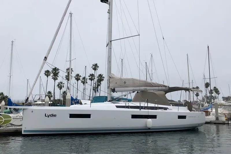  Yacht Photos Pics 2019 Jeanneau Sun Odyssey 440 sailboat docked in marina with palm trees in background.