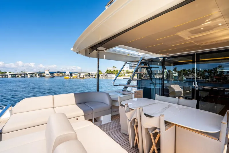  Yacht Photos Pics Luxurious 2022 Prestige X70 yacht with elegant outdoor seating and dining area, overlooking serene waterfront.