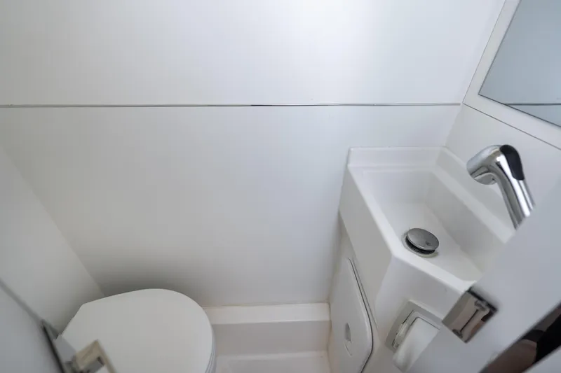  Yacht Photos Pics Compact bathroom in 2022 Prestige X70 yacht with modern sink and toilet.