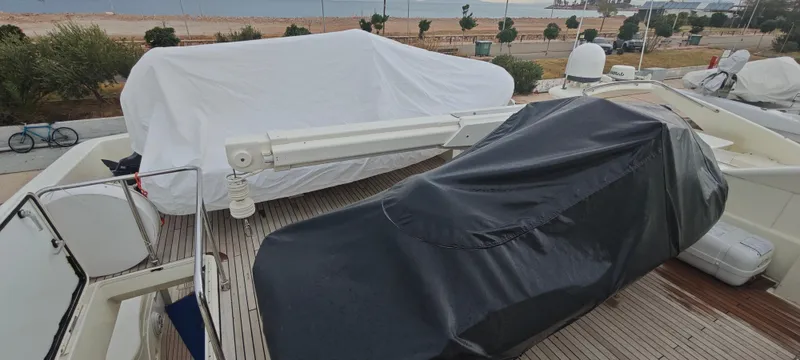  Yacht Photos Pics 2009 Ferretti Yachts 830 deck with covered equipment, docked near a beach.