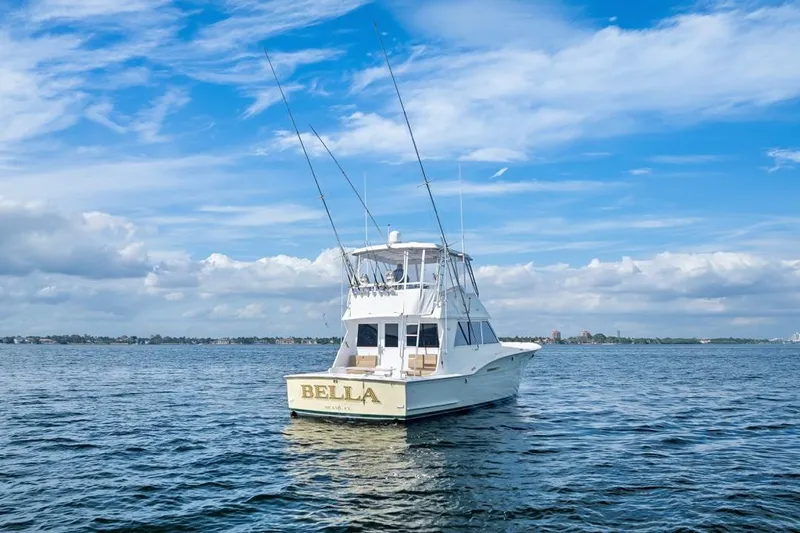 Bella Yacht Photos Pics 1978 Hatteras 45 Convertible boat named "Bella" on open water under blue sky.