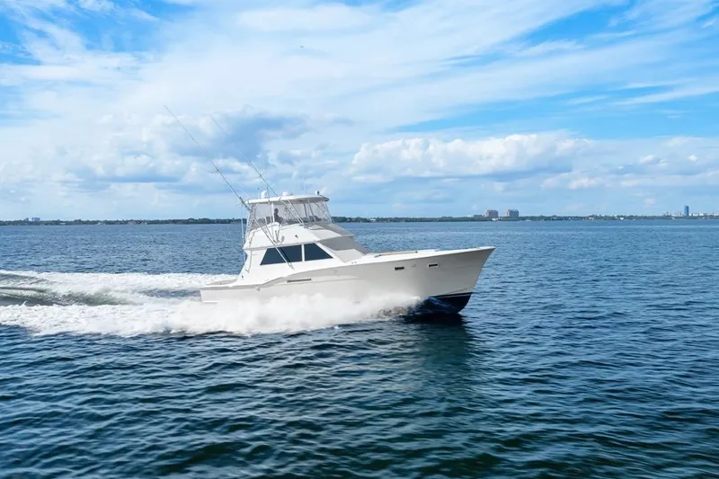 Bella Yacht Photos Pics 1978 Hatteras 45 Convertible yacht cruising on open water under a clear blue sky.