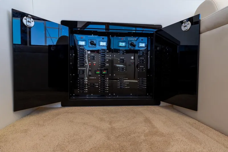 Bella Yacht Photos Pics Electrical panel inside 1978 Hatteras 45 Convertible yacht, featuring open black cabinet doors.