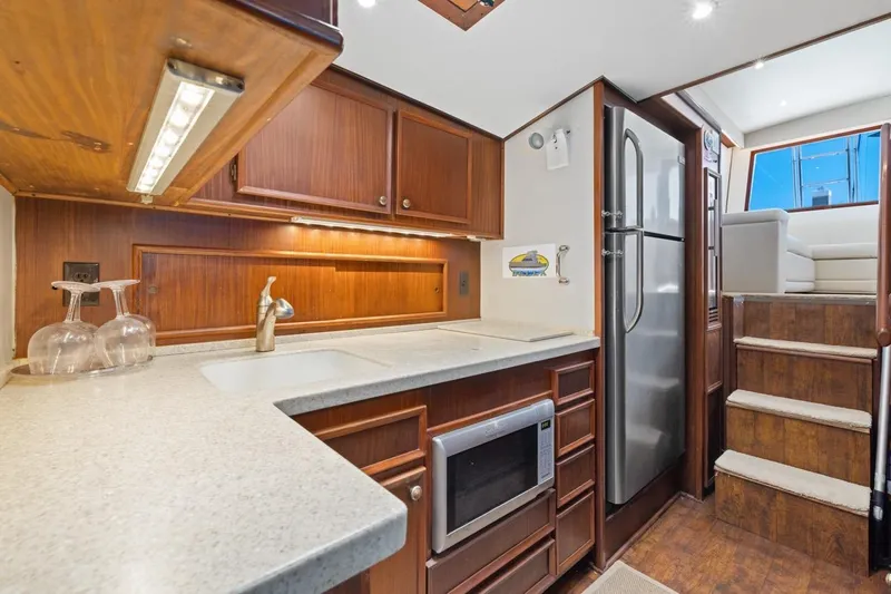 Bella Yacht Photos Pics 1978 Hatteras 45 Convertible yacht kitchen with wood cabinetry and modern appliances.