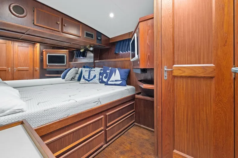 Bella Yacht Photos Pics 1978 Hatteras 45 Convertible yacht cabin with wooden interior and nautical-themed pillows.