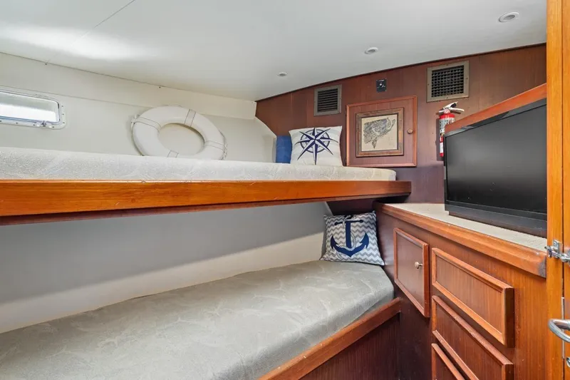 Bella Yacht Photos Pics Cozy cabin interior of 1978 Hatteras 45 Convertible with bunk beds and nautical decor.