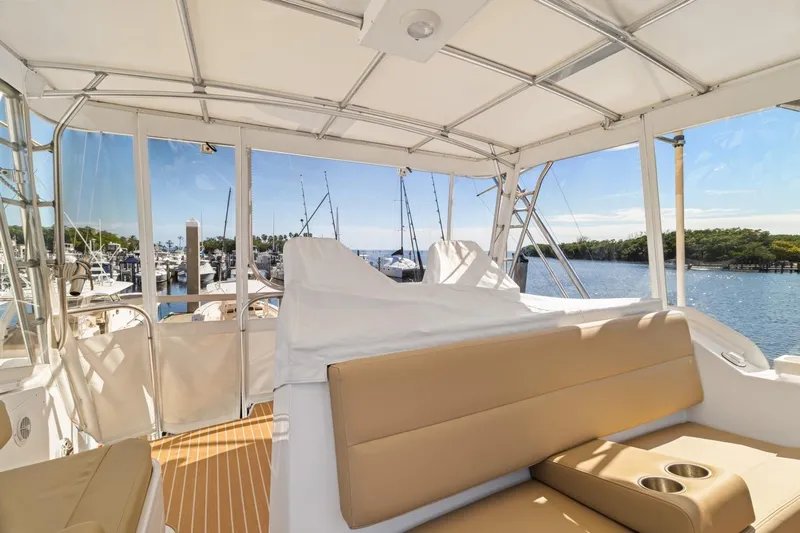 Bella Yacht Photos Pics 1978 Hatteras 45 Convertible yacht interior with beige seating, overlooking marina and water.
