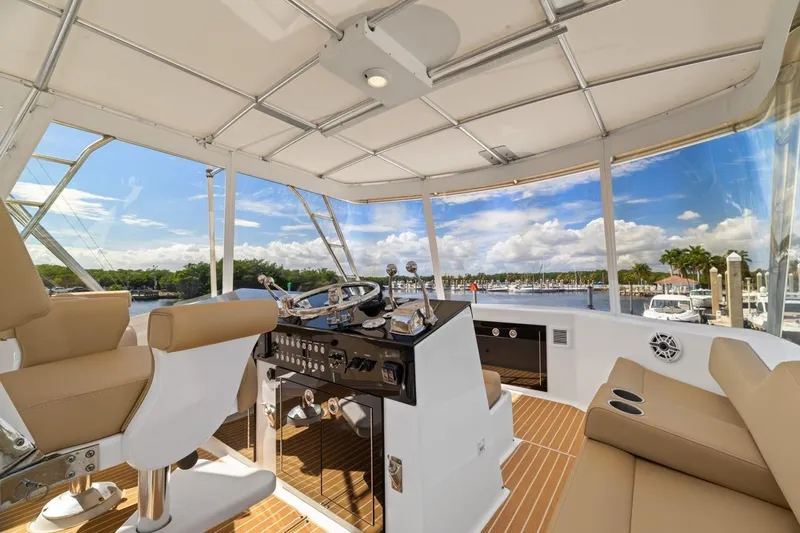 Bella Yacht Photos Pics Interior view of 1978 Hatteras 45 Convertible yacht helm with scenic marina backdrop.