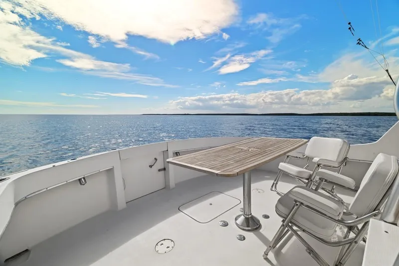 Bella Yacht Photos Pics 1978 Hatteras 45 Convertible yacht deck with chairs, table, and ocean view.