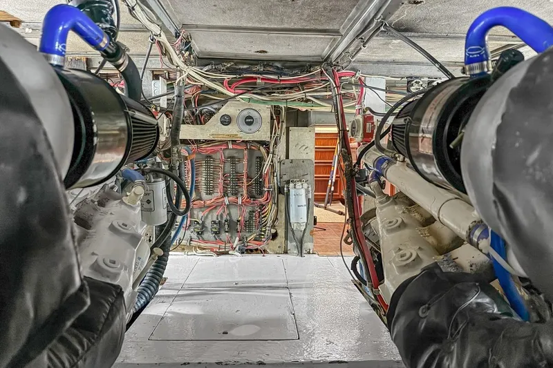 Bella Yacht Photos Pics Engine room of a 1978 Hatteras 45 Convertible boat, showcasing wiring and machinery.