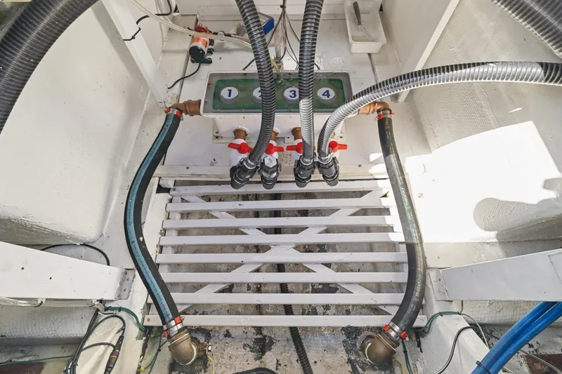 Bella Yacht Photos Pics Engine room of 1978 Hatteras 45 Convertible boat with visible hoses and valves.