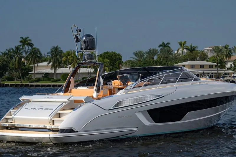 Grey Yacht Photos Pics 2021 Riva 56 Rivale yacht cruising on a sunny day, surrounded by palm trees.