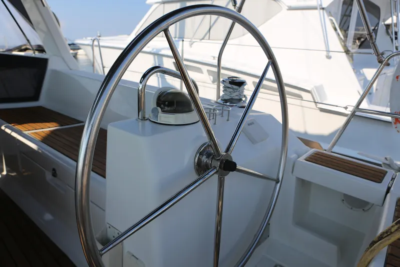 Retox Yacht Photos Pics Steering wheel of a 2014 Beneteau Oceanis 41 sailboat, featuring sleek design and wooden accents.
