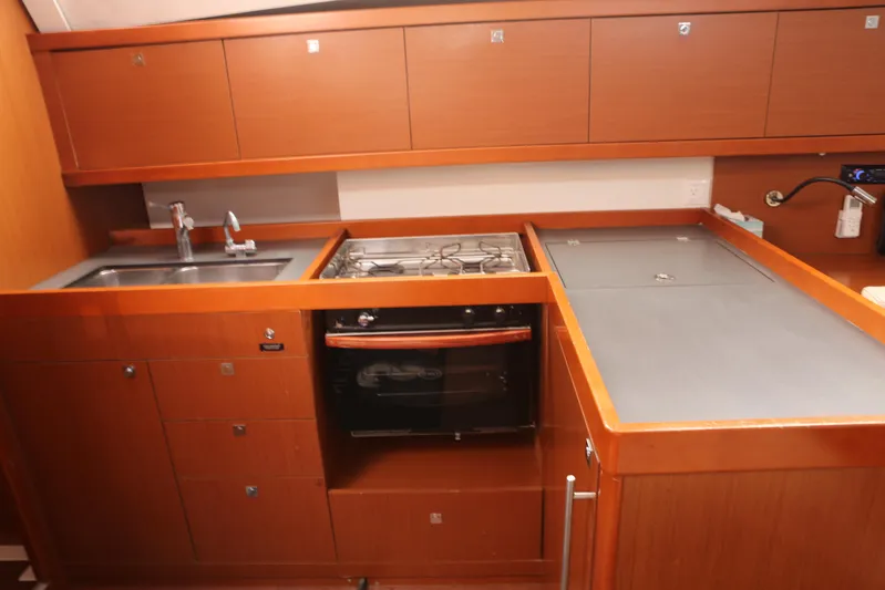 Retox Yacht Photos Pics 2014 Beneteau Oceanis 41 yacht kitchen with wooden cabinetry, sink, stove, and oven.