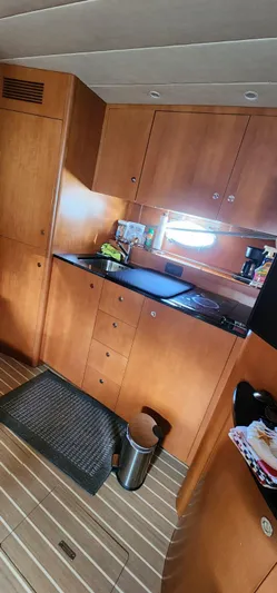 Side Effeot Yacht Photos Pics 2007 Uniesse 54 Sport yacht kitchen with wooden cabinets and modern appliances.