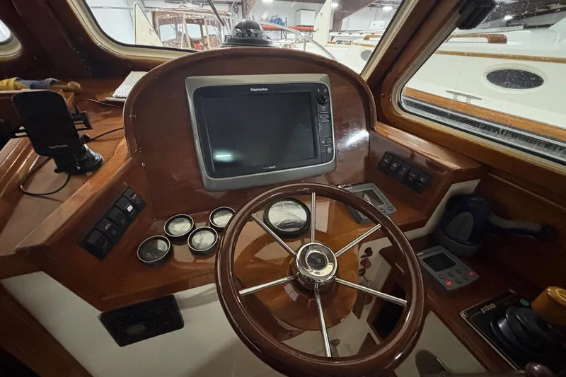Josie Yacht Photos Pics Helm of 2000 Hinckley 36 Picnic Boat EP with navigation equipment and wooden steering wheel.