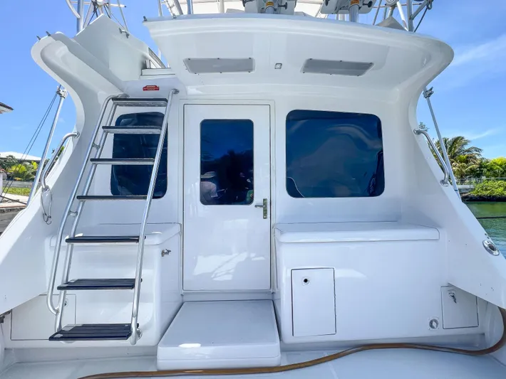 Goggle Eye Yacht Photos Pics Luhrs 400 Convertible 2000 model, rear view with ladder and door, docked by water.