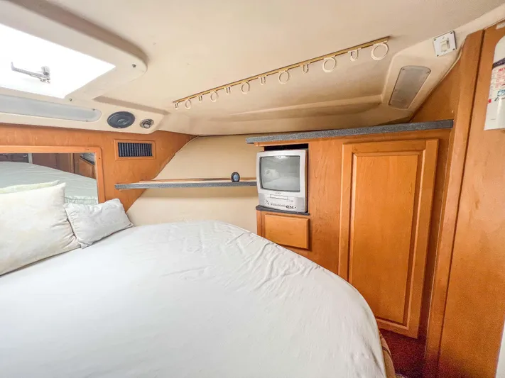 Goggle Eye Yacht Photos Pics Luhrs 400 Convertible 2000 model bedroom with TV and storage cabinets.