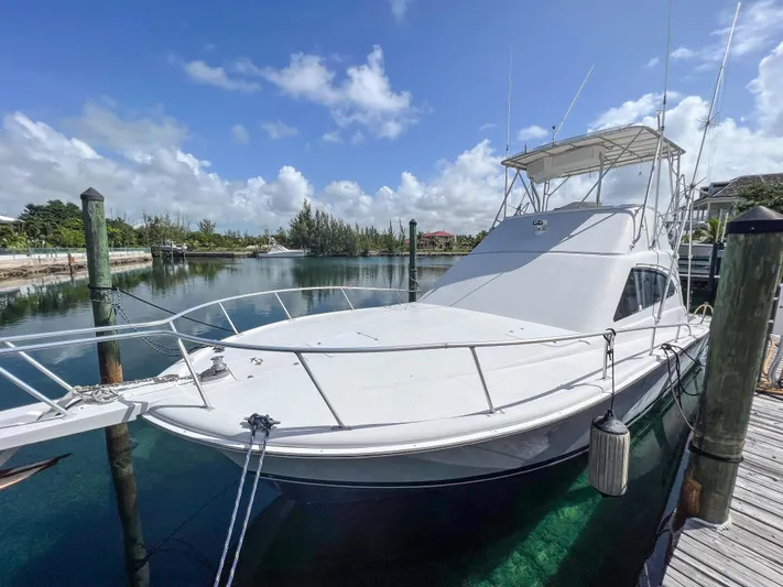Goggle Eye Yacht Photos Pics 2000 Luhrs 400 Convertible yacht docked in a serene marina.