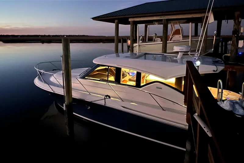 Silver Lining Yacht Photos Pics 2017 Tiara Yachts C39 Coupe docked at sunset, illuminated interior, serene water setting.