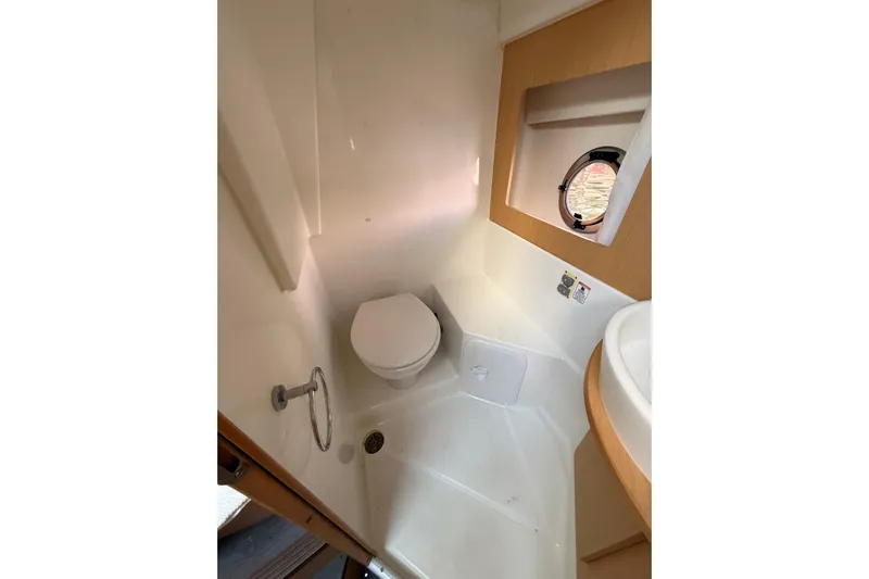  Yacht Photos Pics 2013 Beneteau Flyer GT 34 bathroom with toilet, shower, and porthole window.