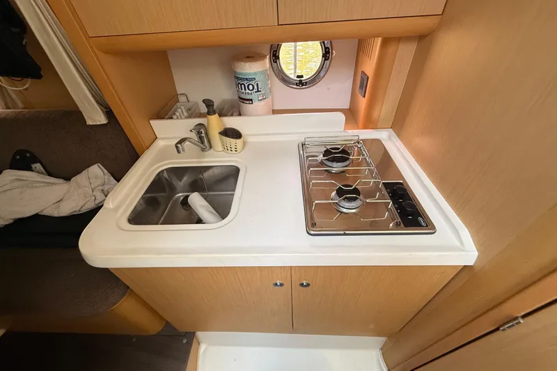  Yacht Photos Pics Compact kitchen area in 2013 Beneteau Flyer GT 34 with sink and two-burner stove.
