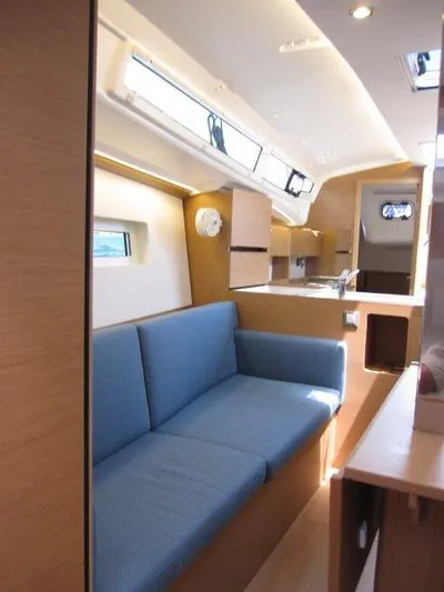  Yacht Photos Pics 2025 Jeanneau Sun Odyssey 350 interior with blue sofa and modern kitchen.