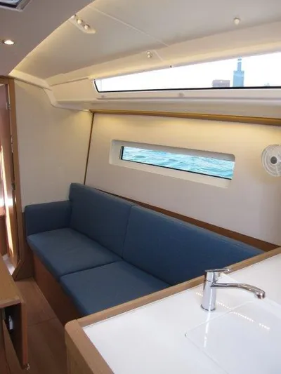  Yacht Photos Pics Interior of 2025 Jeanneau Sun Odyssey 350 yacht with blue sofa and modern design.