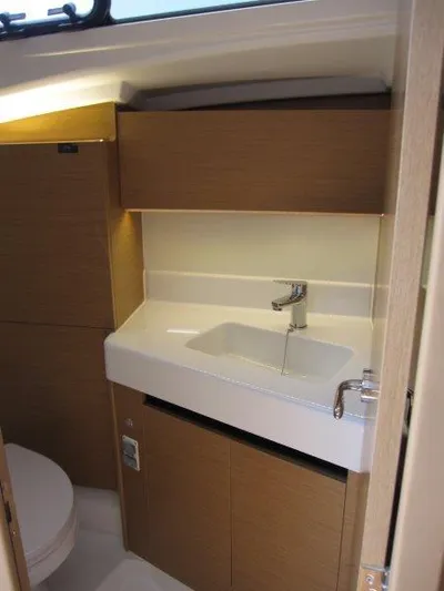  Yacht Photos Pics 2025 Jeanneau Sun Odyssey 350 bathroom with modern sink and wooden cabinetry.