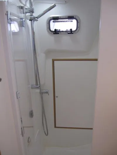  Yacht Photos Pics 2025 Jeanneau Sun Odyssey 350 yacht bathroom with shower and porthole window.