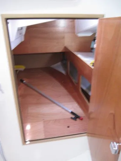  Yacht Photos Pics 2025 Jeanneau Sun Odyssey 350 interior cabin with wooden finish and storage space.