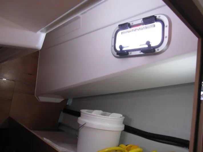  Yacht Photos Pics Interior view of 2025 Jeanneau Sun Odyssey 350 sailboat with porthole and storage area.