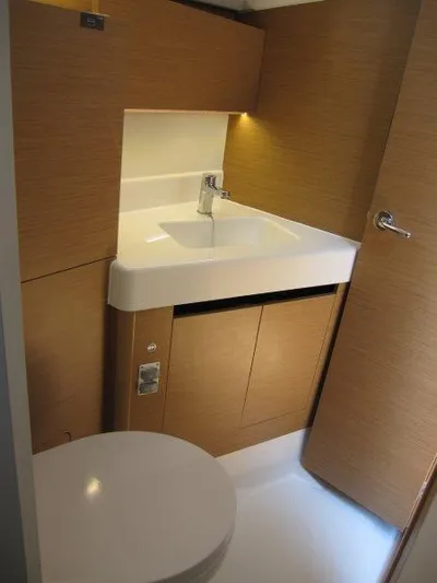  Yacht Photos Pics 2025 Jeanneau Sun Odyssey 350 yacht bathroom with modern sink and wooden cabinetry.