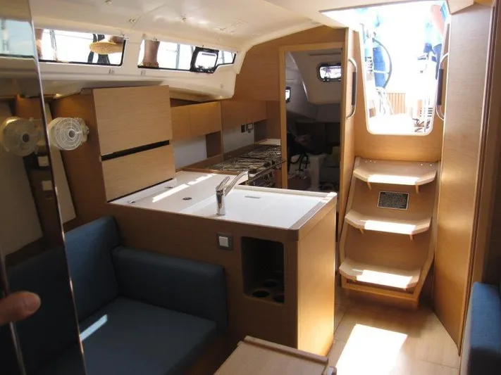  Yacht Photos Pics Interior of 2025 Jeanneau Sun Odyssey 350 sailboat, featuring modern kitchen and seating area.