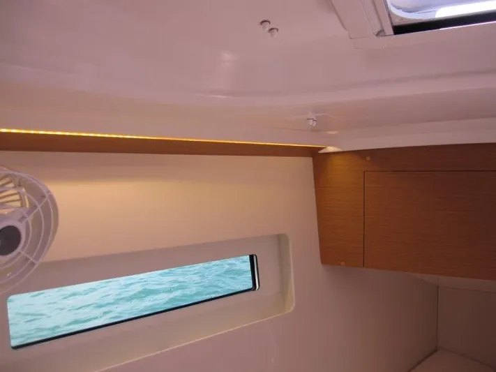  Yacht Photos Pics Interior view of 2025 Jeanneau Sun Odyssey 350 yacht cabin with window and fan.