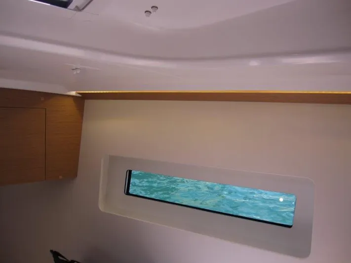  Yacht Photos Pics Interior view of 2025 Jeanneau Sun Odyssey 350 yacht cabin with window.