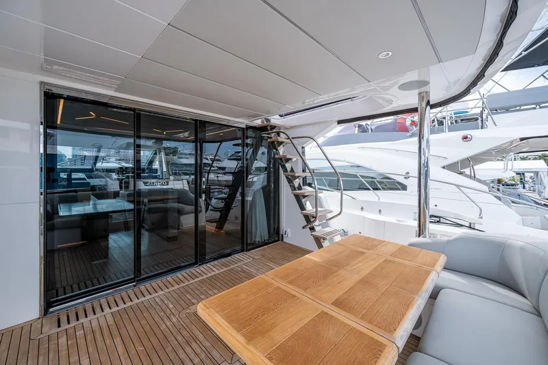 Lucky Ladies Yacht Photos Pics Luxurious Sunseeker Manhattan 68 yacht deck with wooden table and modern seating, 2022 model.
