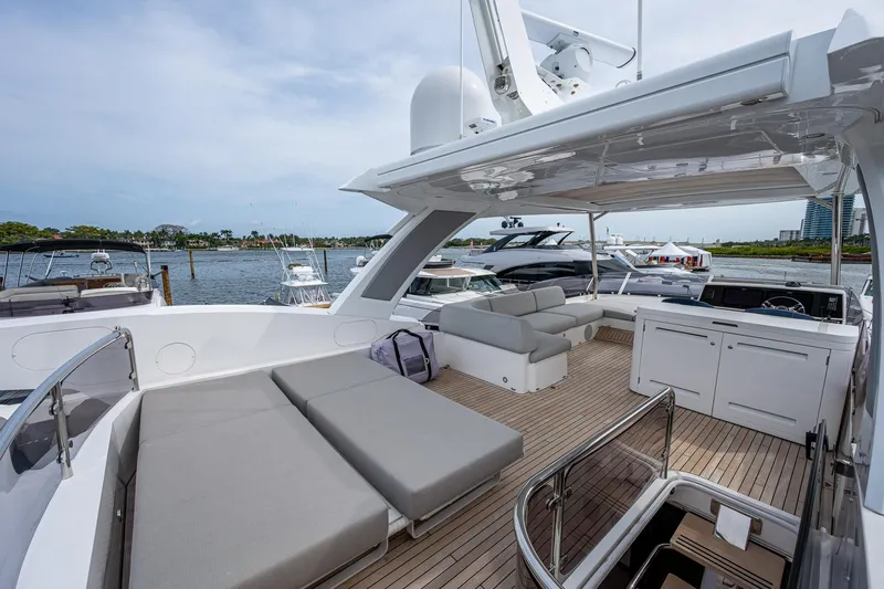 Lucky Ladies Yacht Photos Pics Luxurious Sunseeker Manhattan 68 yacht deck with seating, 2022 model, docked by the water.