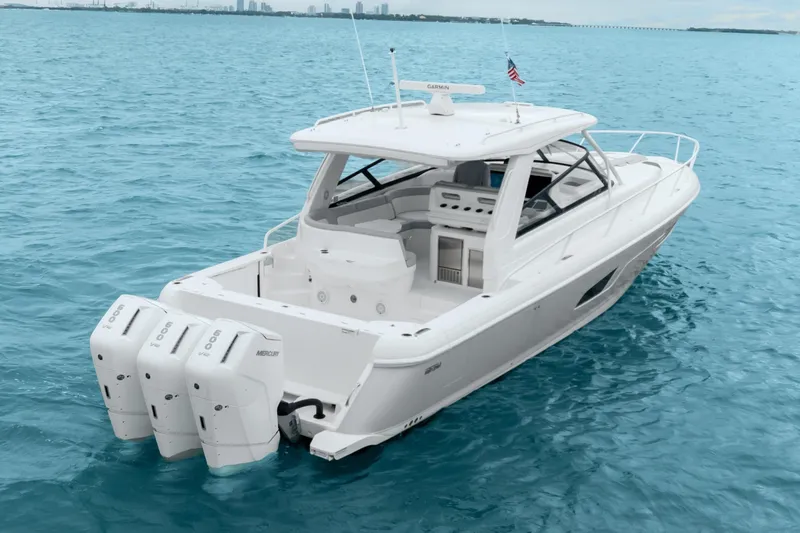  Yacht Photos Pics 2024 Intrepid 477 Evolution boat on clear blue water, featuring triple Mercury engines.